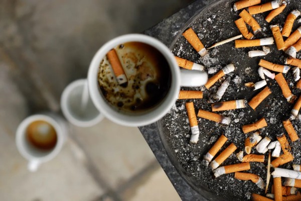 Dettaglio di tazzine di caffè e mozziconi di sigaretta in un posacenere, illustrazione per il racconto Al Cyber Café.